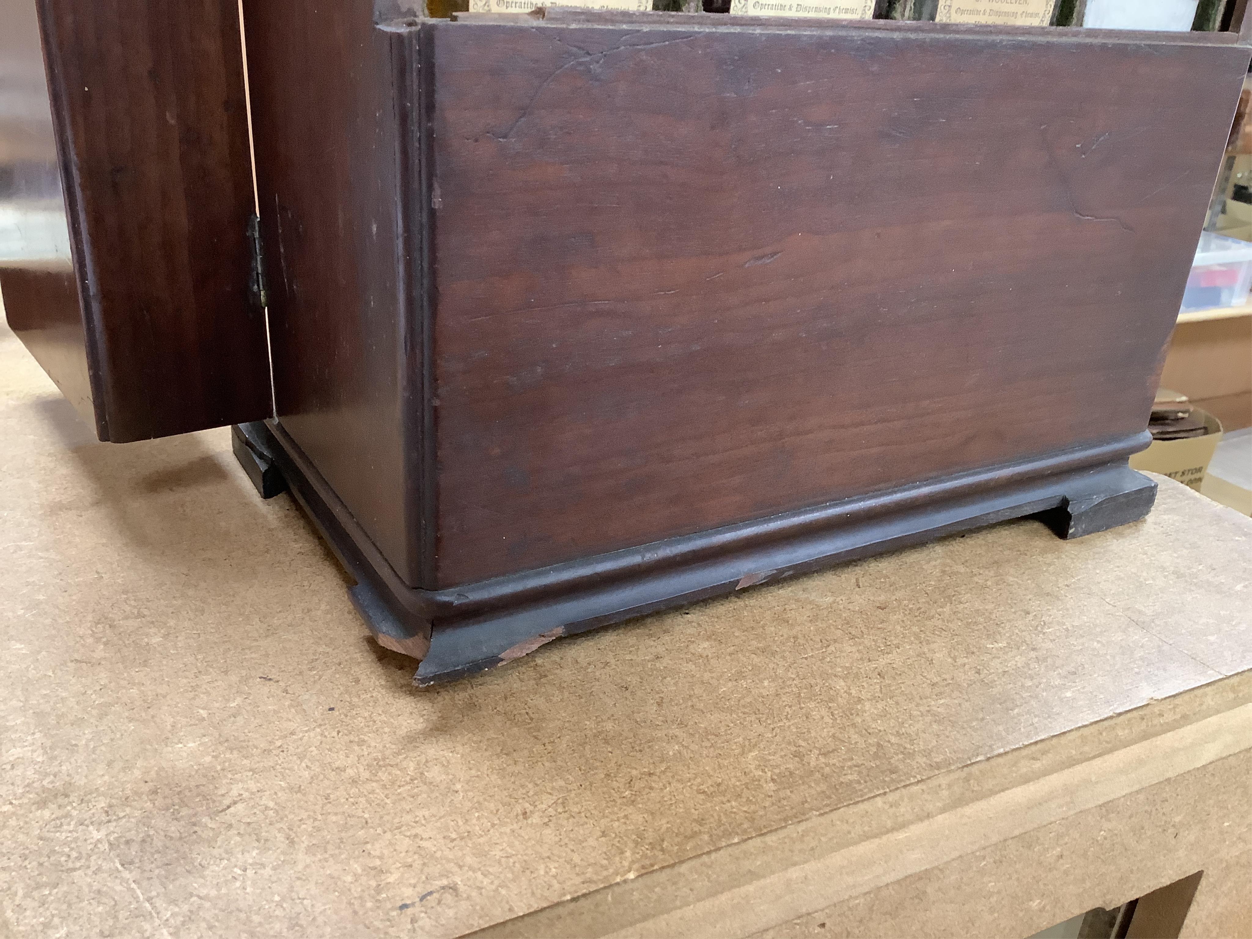 A 19th century mahogany apothecary cabinet, containing 20 bottles of various medicinal compounds and poisons, some sealed, all with paper labels, mainly for ‘C. Woollven, Operative & Dispensing Chemist, 108, High Street,